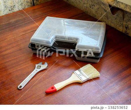 closed organizer for small items with a wrench and a brush on wood 138253652