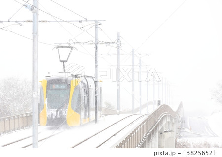 雪の中を走る路面電車 138256521