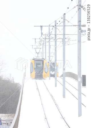 雪の中を走る路面電車 138256529