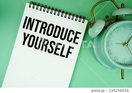 Introduce Yourself text with alarm clock flat lay on green background 138256838