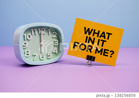 What In It For Me? text and alarm clock on blue and purple background 138256850