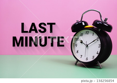Black alarm clock on a pastel green and pink background with the text "Last Minute" 138256854
