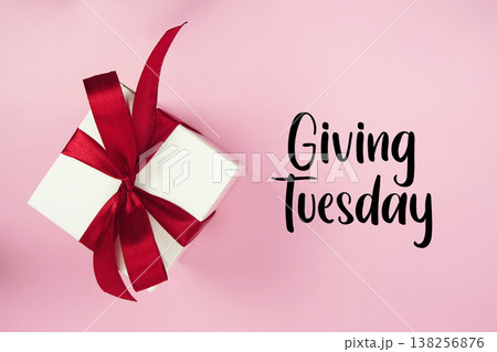 Giving Tuesday text with gift box present on pink background Giving Tuesday text with gift box present on pink background 138256876