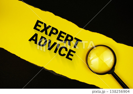 Expert Advice text on yellow with black paper torn ripped and magnifying glass 138256904