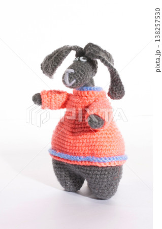 A funny rabbit crocheted from wool on a white background 138257530