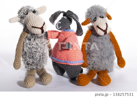 A crocheted rabbit and two sheep, made of wool, on a white background. 138257531