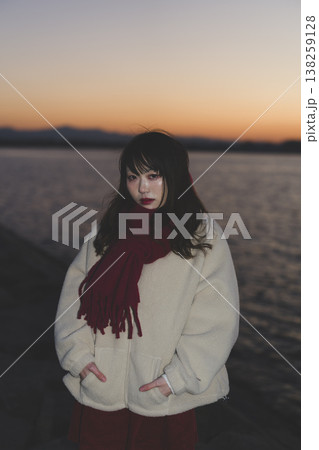 夕暮れの海にいる女性 138259128