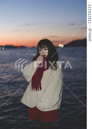 夕暮れの海にいる女性 138259223