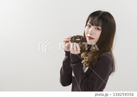 ドーナツを食べる女性 138259358