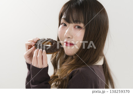 ドーナツを食べる女性 138259370