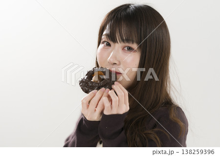 ドーナツを食べる女性 138259396