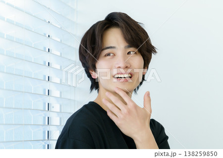 窓際に立つ若い日本人男性のポートレート 138259850