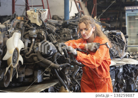 Technician female worker working in garage scrap yard old car part workshop warehouse. Technician female worker working in garage scrap yard old car part workshop warehouse. 138259887