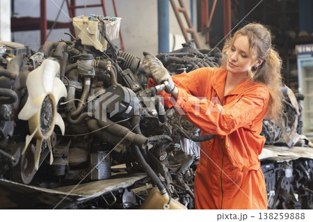 Technician female worker working in garage scrap yard old car part workshop warehouse. Technician female worker working in garage scrap yard old car part workshop warehouse. 138259888