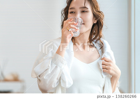 シャワーを浴びてリビングで水分補給する女性 138260266