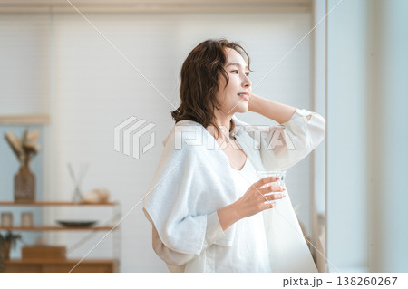 シャワーを浴びてリビングで水分補給する女性 シャワーを浴びてリビングで水分補給する女性 138260267