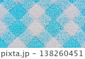 Close-up of a plush textile featuring a soft blue and white diamond pattern. Ideal as a cozy background, showcasing its fluffy texture and vibrant colors. 138260451