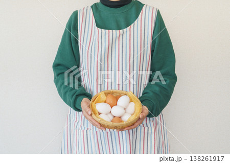 卵を持つエプロンを着た女性 138261917