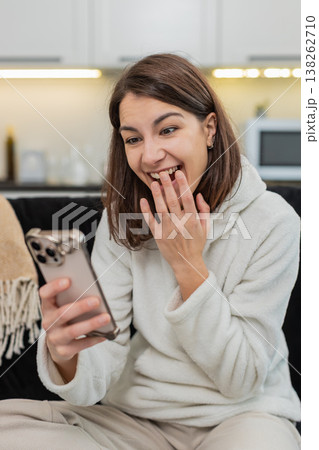 Young woman signs job contract on smartphone covers mouth with joy sends accept reply to offer fast Young woman signs job contract on smartphone covers mouth with joy sends accept reply to offer fast 138262710