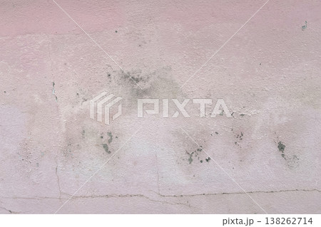 Peeling pink wall with cracked plaster and rough texture, weathered surface revealing gray cement underneath, abstract grunge background. Peeling pink wall with cracked plaster and rough texture, weathered surface revealing gray cement underneath, abstract grunge background. 138262714