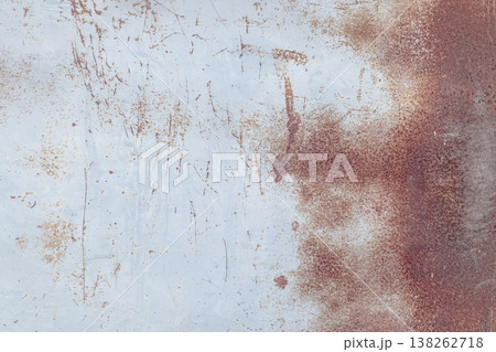 Rusty metal surface with peeling paint, scratches, and oxidized textures, abstract industrial background with warm brown and pale blue tones. Rusty metal surface with peeling paint, scratches, and oxidized textures, abstract industrial background with warm brown and pale blue tones. 138262718