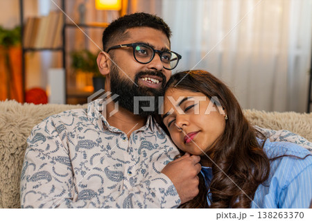 Indian couple man woman sleeping at home, girl resting on shoulder while boy touches hair gently 138263370