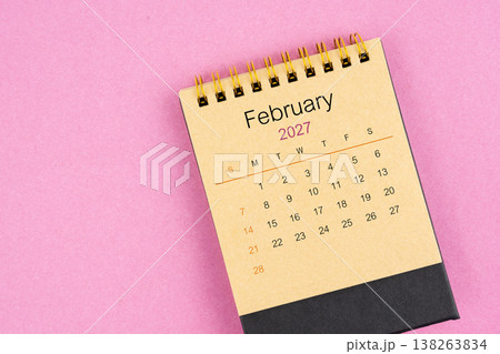 Brown desk calendar for February 2027 on pink color background. Brown desk calendar for February 2027 on pink color background. 138263834