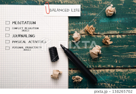Notebook with checklist for balanced life, featuring meditation, journaling, physical activities, and productivity skills, surrounded by crumpled paper and a black pen on a wooden table Notebook with checklist for balanced life, featuring meditation, journaling, physical activities, and productivity skills, surrounded by crumpled paper and a black pen on a wooden table 138265702