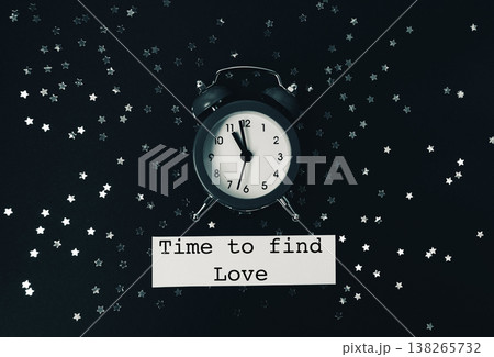 Vintage alarm clock surrounded by silver star confetti on a dark background, conveying the message of love and the passage of time, perfect for romantic themes and celebrations 138265732