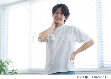 リビングでストレッチをする若い男性 リビングでストレッチをする若い男性 138266418