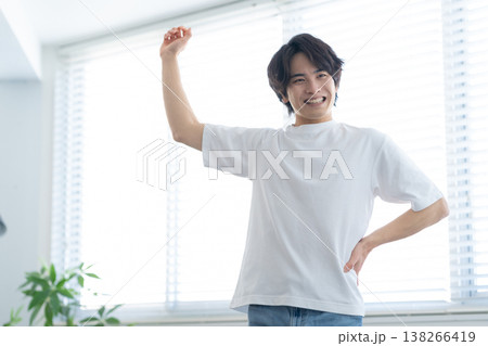 リビングでストレッチをする若い男性 リビングでストレッチをする若い男性 138266419