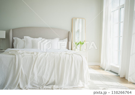 Stylish loft bedroom interior. Spacious design apartment with light walls large windows big bed. Clean modern decoration with elegant furniture in minimalist Scandinavian style 138266764
