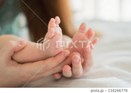 Happy family. Tiny newborn infant male or female baby feet on mother hands. Mother holding newborn child. Mom and her baby. Maternity tenderness parenthood new life concept. Handle with care Happy family. Tiny newborn infant male or female baby feet on mother hands. Mother holding newborn child. Mom and her baby. Maternity tenderness parenthood new life concept. Handle with care 138266776