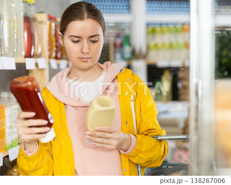 Young woman choosing sauces in the store Young woman choosing sauces in the store 138267006