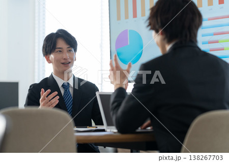 オフィスで会議をする若いビジネスマン オフィスで会議をする若いビジネスマン 138267703