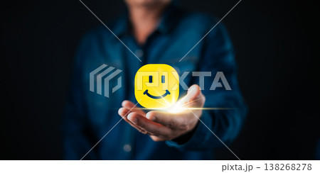 A person holding a glowing smile face icon symbolizes customer satisfaction, positive feedback, happiness, and quality service in business success and relationship management. A person holding a glowing smile face icon symbolizes customer satisfaction, positive feedback, happiness, and quality service in business success and relationship management. 138268278