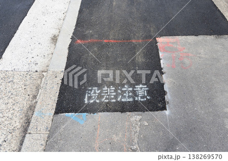 水道工事後の歩道の仮舗装と段差注意を促す文字 水道工事後の歩道の仮舗装と段差注意を促す文字 138269570