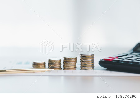 Stacks of coins on financial report with charts, blurred calculator in background, symbolizing savings, investment growth, budgeting and wealth management for business planning strategy. saving Stacks of coins on financial report with charts, blurred calculator in background, symbolizing savings, investment growth, budgeting and wealth management for business planning strategy. saving 138270290
