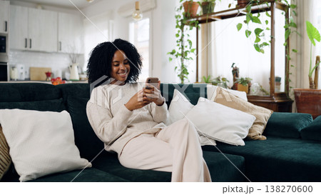 Young woman relaxing on sofa using smartphone Young woman relaxing on sofa using smartphone 138270600