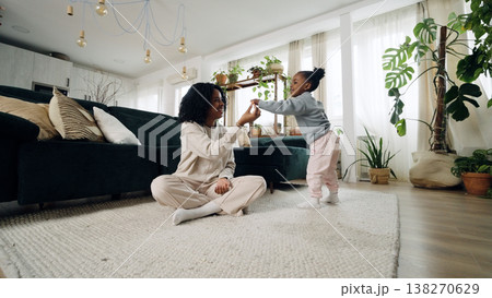 Black mother and daughter playing in living room Black mother and daughter playing in living room 138270629