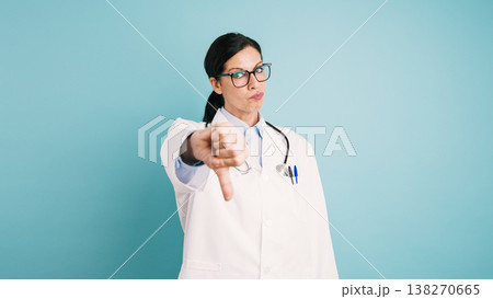 Doctor giving thumbs down gesturing strong disapproval 138270665
