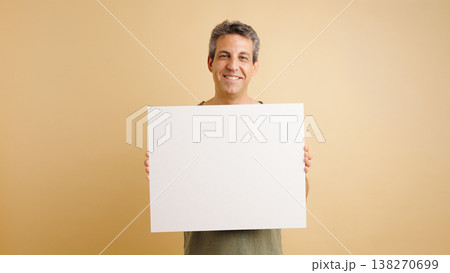 Man holding blank blank sign smiling at camera Man holding blank blank sign smiling at camera 138270699