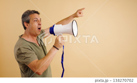 Man holding megaphone shouting pointing communicating direction Man holding megaphone shouting pointing communicating direction 138270702
