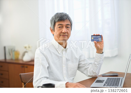 リビングでパソコンとカードを見る60代の男性 138272601