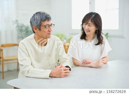 リビングで楽しく会話する60代の夫婦 リビングで楽しく会話する60代の夫婦 138272629