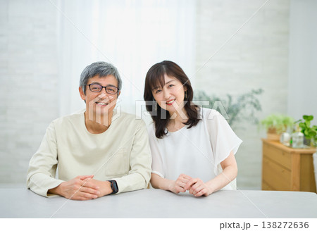 リビングで楽しく会話する60代の夫婦 リビングで楽しく会話する60代の夫婦 138272636