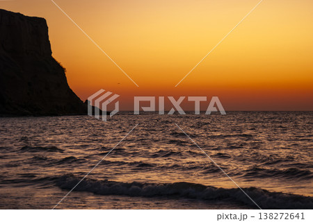 Golden Sunset over the Sea with a Coastal Cliff Silhouette in Ukrainian Crimea 138272641