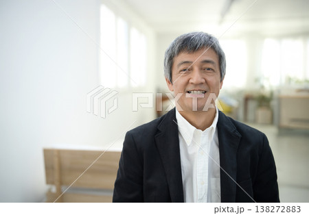 部屋でジャケットを着て微笑む60代の男性 部屋でジャケットを着て微笑む60代の男性 138272883