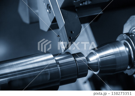 High-precision CNC lathe machine performing a finish cut on a metal shaft part for a smooth surface finish. 138273351