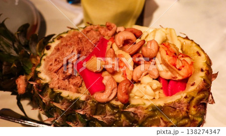 close up of Thai pineapple fried rice with shrimp, cashews, bell peppers, pineapple chunks and pork floss filled in a Hollowed pineapple bowl with copy space close up of Thai pineapple fried rice with shrimp, cashews, bell peppers, pineapple chunks and pork floss filled in a Hollowed pineapple bowl with copy space 138274347